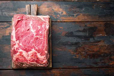 Striploin bifteği, çiğ et kasaplığı, eski ahşap masa, üst görünüm, metin için kopyalama alanı ile kesilmiş