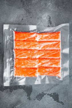 Vakum paketindeki yengeç çubukları, gri arkaplanda, üst görünüm düz yerde