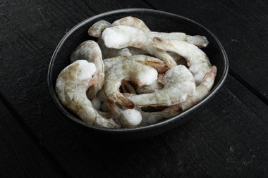 Kaplan karideslerinde donmuş kabuk ya da Asya kaplan karidesleri seti, siyah ahşap arka planda.