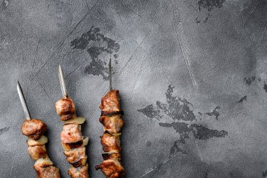 Şiş kebap et, soğan ve domates seti, gri taş masa arkaplanı, üst görünüm düz, metin için kopyalama alanı