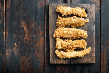 Kızarmış çıtır tavuk çizgili parçalar eski siyah ahşap masa üzerinde, üst manzara, fotokopi alanı ile..