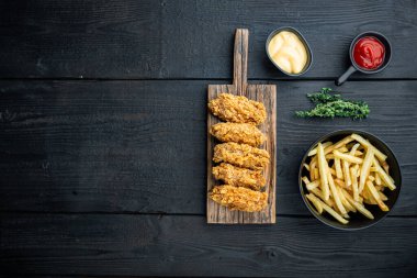 Közlenmiş tavuk kanatları siyah ahşap arka planda, üst görünümde, metin için yeri olan..