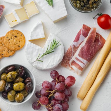 Peynir ve meze çeşitleri, beyaz arka planda, düz yatıyordu.