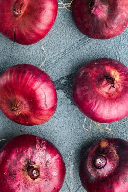 Kırmızı soğan, gri arkaplanda, üst görünüm düz yerde.