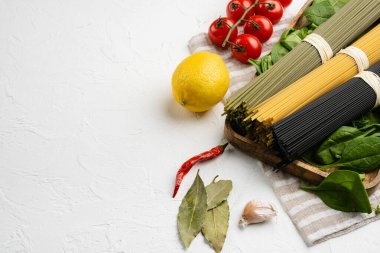 Beyaz taş masa zemininde, metin için kopyalama alanı ile renklendirilmiş İtalyan makarna seti