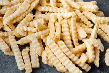 Donmuş fırın cipsi dilimlenmiş patates seti, gri arka planda.