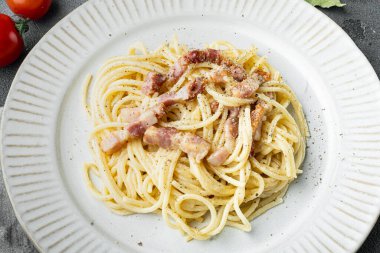 Bir tabak spagetti Carbonara, modern İtalyan makarna tarifi guanciale, yumurta ad pecorino romano peyniri seti, gri taş arka planda.