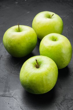 Taze yeşil elma seti, siyah siyah taş masa zemininde.