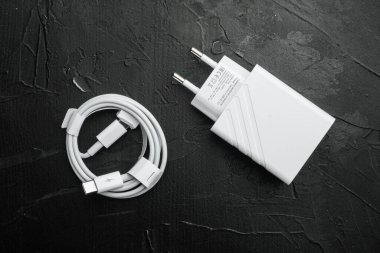 Akıllı telefon için aksesuarlar, şarj seti, siyah taştan masa arkaplanı, üst görünüm düz.