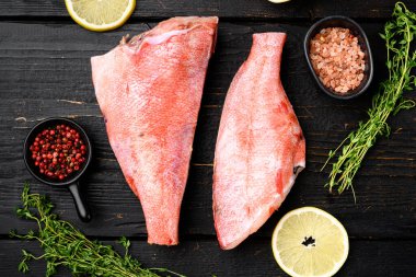 Çiğ kırmızı levrek seti, siyah ahşap masa arkaplanı, üst manzara düz yatıyordu.