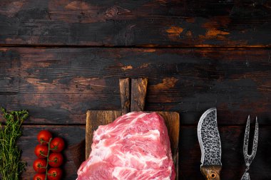 Taze çiğ domuz eti seti, malzemeler ve otlarla birlikte, eski koyu ahşap masa zemininde, üst görünümü düz, metin alanı için kopya alanı ile