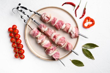 Şiş setinde marine edilmiş çiğ kebap, beyaz taş masa zemininde, en üstte düz konum