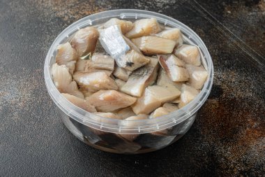 Köy arka planında marine edilmiş, yağda doğranmış ringa balığı.