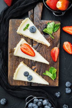 Çilekli, böğürtlenli ve nane arkaplanlı bir cheesecake.