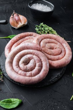 Siyah arka planda çiğ et sosisi.