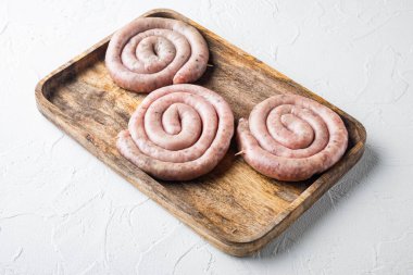 Beyaz arka planda geleneksel spiral sette çiğ salyangoz sosisi.
