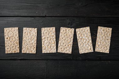 Çıtır ekmek seti, siyah ahşap masa arkaplanı, üst görünüm düz yatay, metin alanı için kopyalama alanı