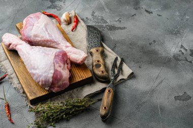 Taze pişmemiş hindi bacakları, ahşap kesim tahtası, gri taş masa arka planı, metin için kopyalama alanı