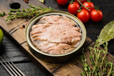 Siyah ahşap masa arkaplanında ton balığı konservesi aç