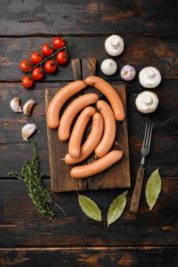 Çiğ domuz eti ve sığır eti karışımı sosis seti, eski koyu ahşap masa arkaplanı, üst görünüm düz yatıyordu