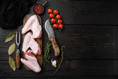 Taze çiğ ördek kanatları seti, siyah ahşap masa arkaplanı, üst görünüm düz, metin için kopyalama alanı ile