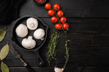 Çiğ mantar şampiyonları seti, siyah ahşap masa arkaplanı, üst görünüm düz yatay, metin için kopyalama alanı ile