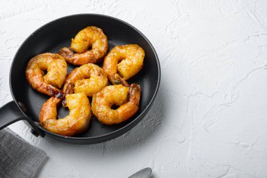 Izgara mango baharatlı köri karidesleri, kızarmış demir tavada, beyaz arka planda, kopyalama alanı ve metin için yeri var.