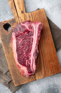 Taze, büyük ve iştah açıcı kuru eski kulüp biftek seti, gri taş arka planda, üst manzara düz yatıyordu