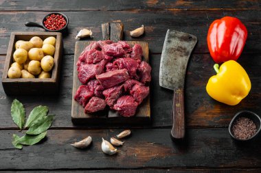 Güveç ya da gulaş karışımı. Tatlı dolma biber ve patatesle hazırlanmış. Eski, siyah ahşap masa üzerinde.