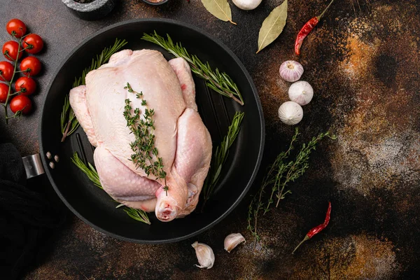 Organic raw whole chicken set, on old dark rustic table background, top view flat lay, with copy space for text