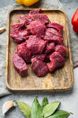 Çiğ organik et veya kuzu eti, gri taştan arka planda.