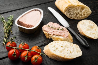 Taze tavuk ciğeri ekmek seti üzerinde konserve ezmesi, siyah ahşap masa arkasında