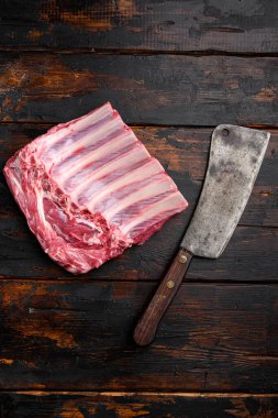 Fransız kuzu pirzolası seti, eski koyu ahşap masa arkaplanı, üst görünüm düz, metin için kopyalama alanı var.