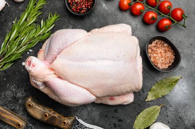 Organik çiğ tavuk seti, siyah taştan masa arkaplanı, üst manzara düz.