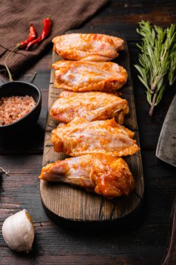 Baharatlı Tavuk Kanatları seti, eski, siyah ahşap masa arka planında.