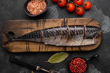 Taze balık uskumrusu seti, siyah taştan masa arkaplanı üzerinde, üst görünüm düz yatıyordu.