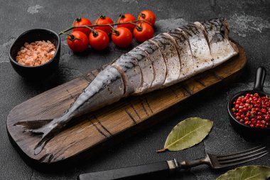 Terbiye edilmiş uskumru seti, siyah taştan masa zemininde.