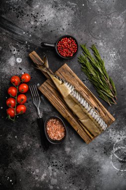 İştah açıcı tütsülenmiş balık seti, siyah taş masa arkaplanı, üst görünüm düz, metin için kopyalama alanı ile