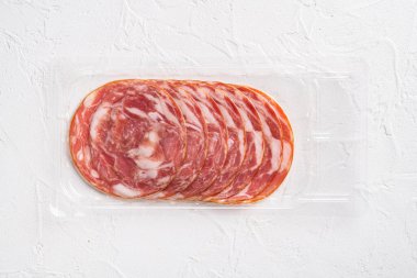 Jamon Serrano geleneksel İspanyol mutfağı domuz eti paketi seti, beyaz taş masa arkaplanı, üst görünüm düz, metin alanı için fotokopi alanı
