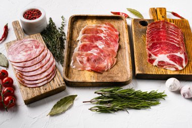 İtalyan dilimlenmiş sosis seti, beyaz taş masa arkasında.