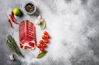 İtalyan usulü pastırma Pancetta seti, gri taş masa arkaplanı, üst görünümü düz, metin için kopyalama alanı var.