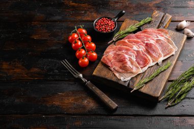 Prosciutto dilimleri, eski koyu ahşap masa arka planında, metin için kopyalama alanı ile