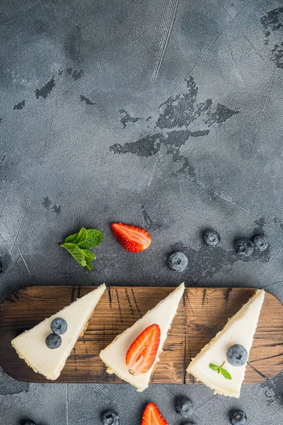 New York cheesecake veya taze berrie ile klasik cheesecake, gri arka planda, üst görünüm düz metin alanı ile yatıyordu