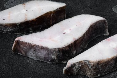 Frozen fish cut set, on black dark stone table background