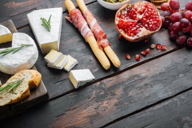 Klasik İtalyan antipasti seti, koyu ahşap arkaplan ve metin için kopya alanı var.