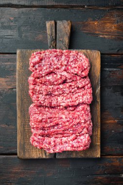 Raw minced fresh meat, on old dark  wooden table background, top view flat lay