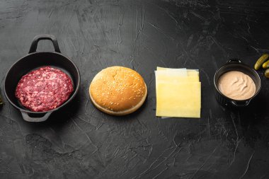 Beef burger ingredients set, on black stone background, with copy space for text