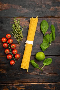 Bunch of spaghetti, raw pasta set, on old dark  wooden table background, top view flat lay