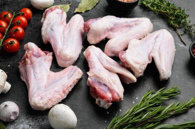 Raw turkey wings set, on black dark stone table background