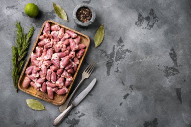 Raw chicken hearts meat set, on gray stone table background, top view flat lay, with copy space for text